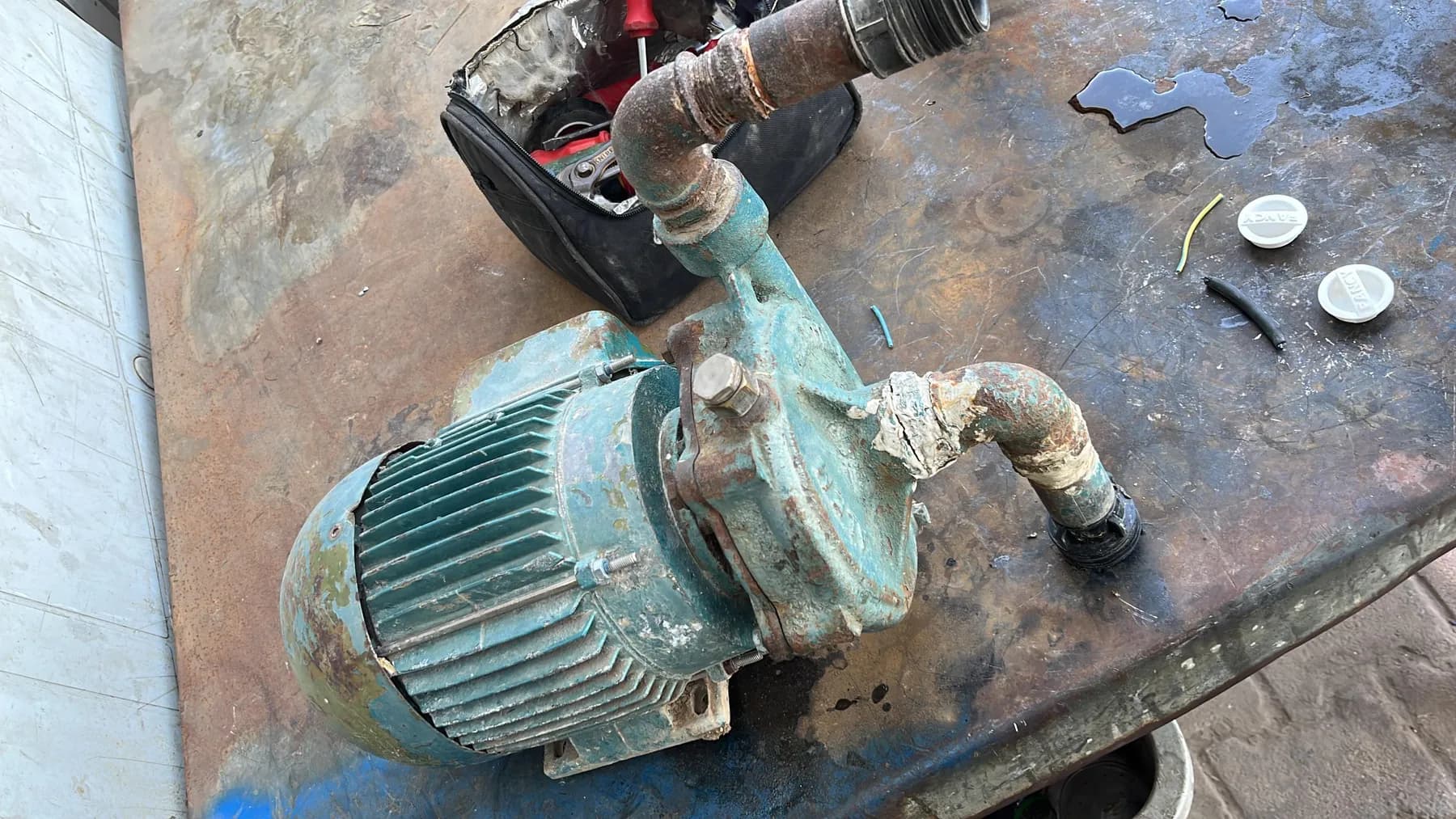 Çalışma tezgâhında sökülmüş elektrik motoru ve pompa gövdesi